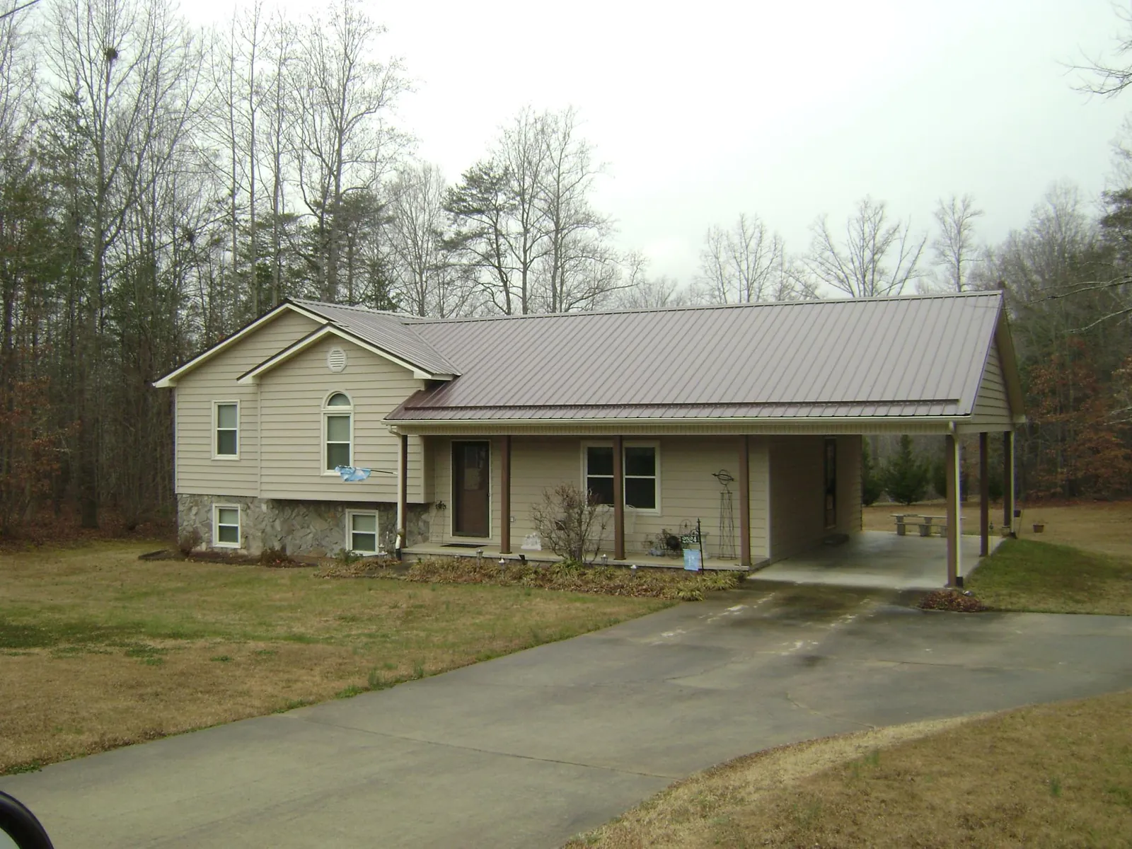 Brown metal roof on a tan split level home with an attached carport in Marion